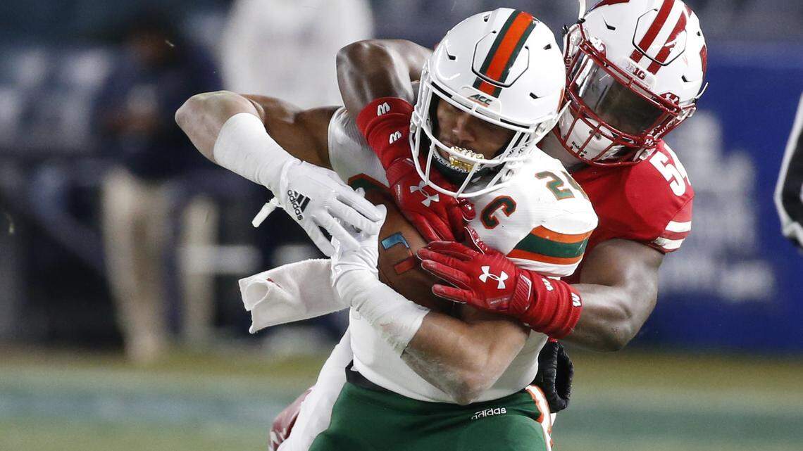 Miami Hurricanes running back Travis Homer (24) attempts to stay in bounds as Wisconsin Badgers linebacker Chris Orr (54) makes the stop in the first quarter as the Miami Hurricanes play against the Wisconsin Badgers in the 2018 New Era Pinstripe Bowl at Yankee Stadium in Bronx, N.Y. on Thursday, December 27, 2018.