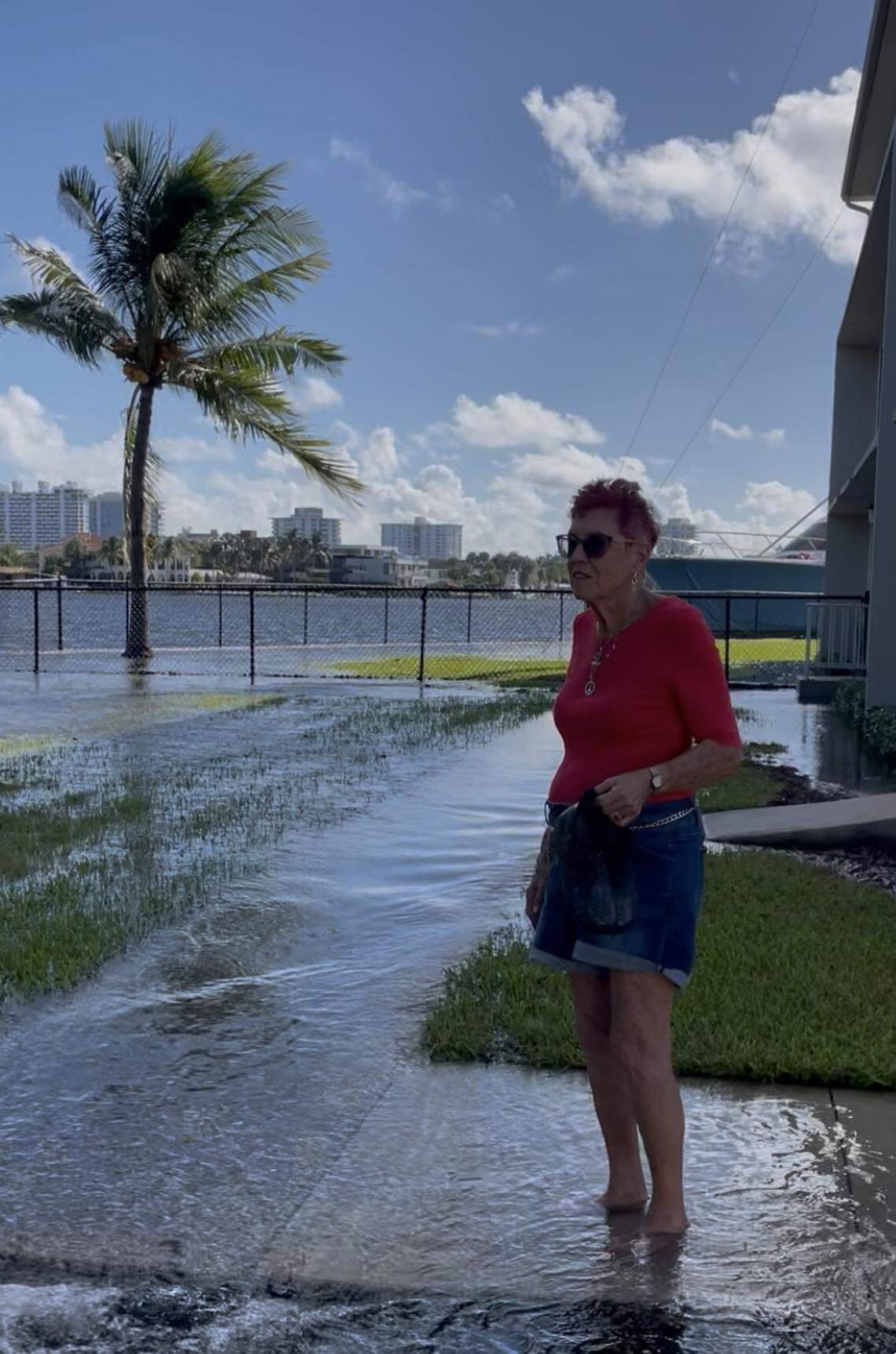 Cathy Sutter, who has lived at the waterfront Gateway Terrace senior community in Fort Lauderdale, stands in flood waters pushed in from the Middle River by king tides on Wednesday. She says the seasonal tides have gotten worse over her 15 years there but residents have learned to adapt. ‘This is the price we pay for living here,’ said Sutter.
