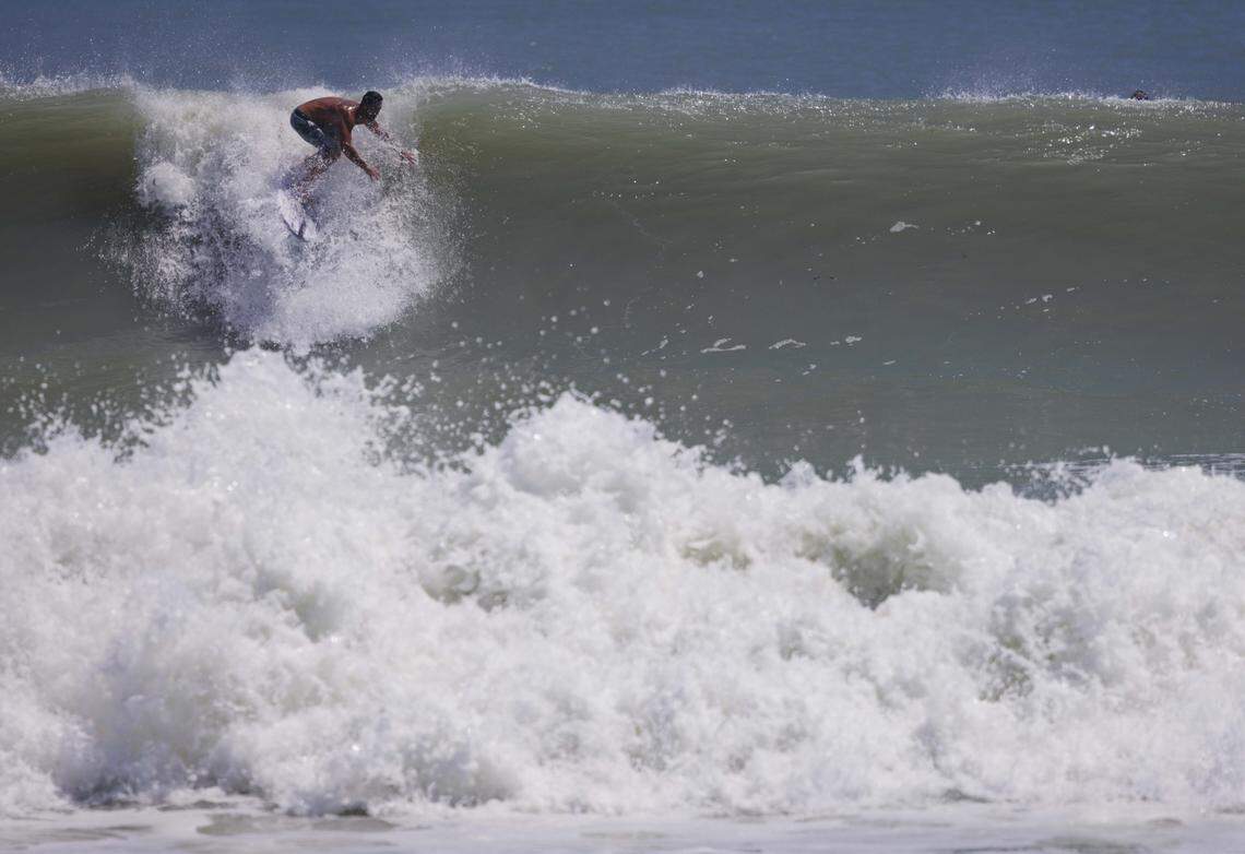 A local surfer catches a wave during the morning on Thursday, Aug. 21, 2025, off the beach in Stuart, Fla. Surfers estimated that waves ranged from 8 - 12 feet all morning.