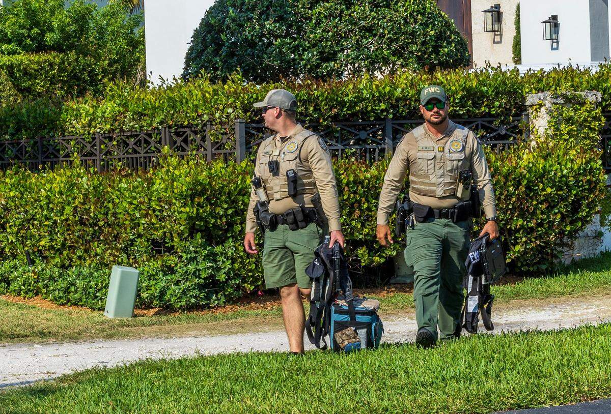 Florida Fish and Wildlife Conservation Commission officers exit the Coral Gables home of Carlos Guillermo ‘Bill’ Alonso,  where police say a boat matching the description of the vessel that struck and killed Ella Adler near the Nixon Beach sandbar on Saturday, May 11, 2024, was located and seized Tuesday, May 14, 2024.