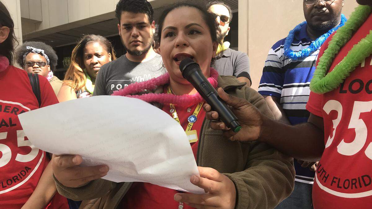 Wendy Bonilla, who works at a sandwich shop renting space at Miami International Airport, praises a new county ordinance requiring a "living wage" for businesses operating in county facilities like MIA. She spoke at a May 23, 2018 press conference outside County Hall that was organized by labor unions, including Service Employees International. Mayor Carlos Gimenez vetoed the ordinance later in the day.