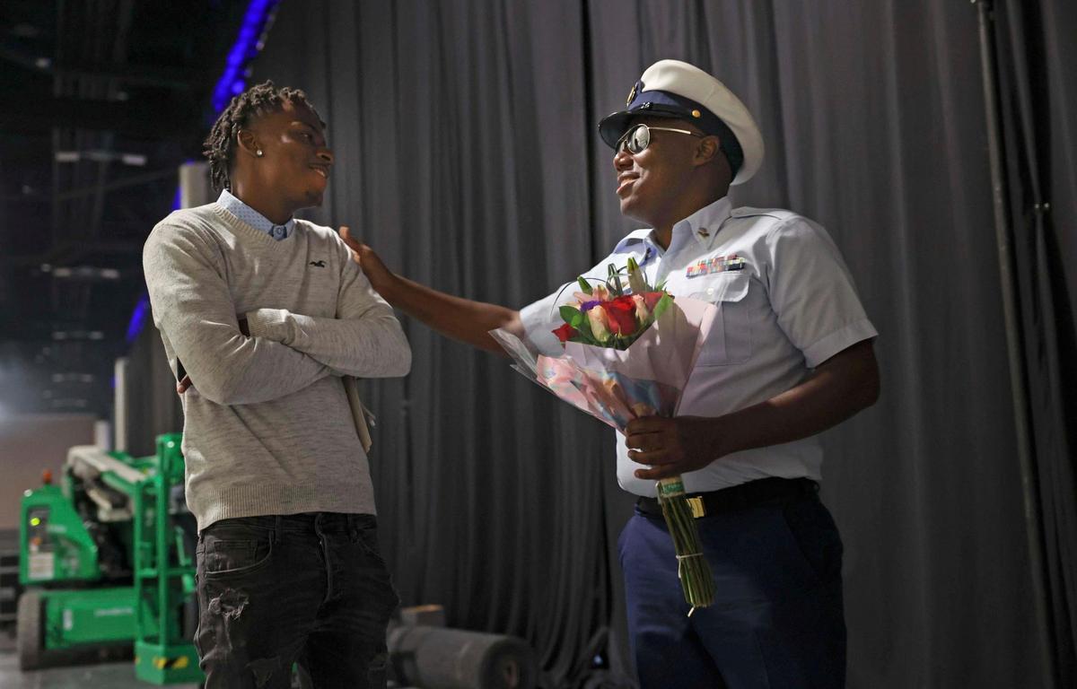 Marcus Roberts, United States Coast Guardsman, right, thanks his cousin, Trovex Bain, for helping him surprise his mother, Jennifer Freeman, 54, while standing backstage before her graduation from Broward College at the Broward County Convention Center in Fort Lauderdale on Thursday, May 5, 2022. Freeman helped raise Bain as well. “Both of them are my boys,” Freeman said.