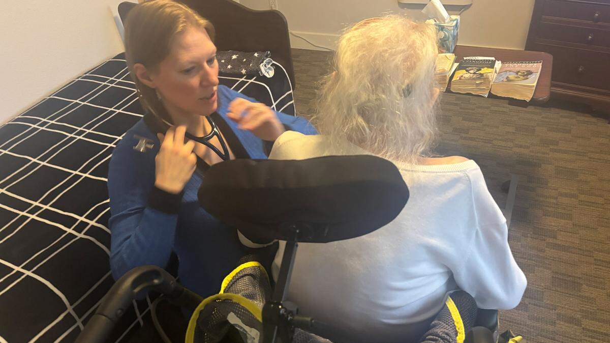 Stephanie Johnson, a geriatric nurse practitioner, checks her patient Ellen with a stethoscope during a hospice consult.