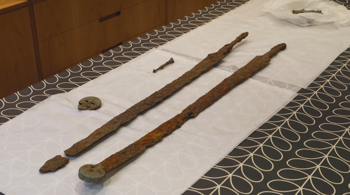 A close-up photo shows the ancient Roman swords.