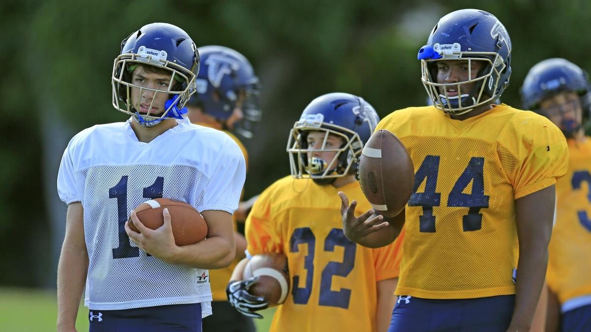Brandon Yanes (11) and Kyon White Royal (44) watch as they prepare to run drills during football practice at Palmer Trinity School on Tuesday, Oct. 30, 2018.