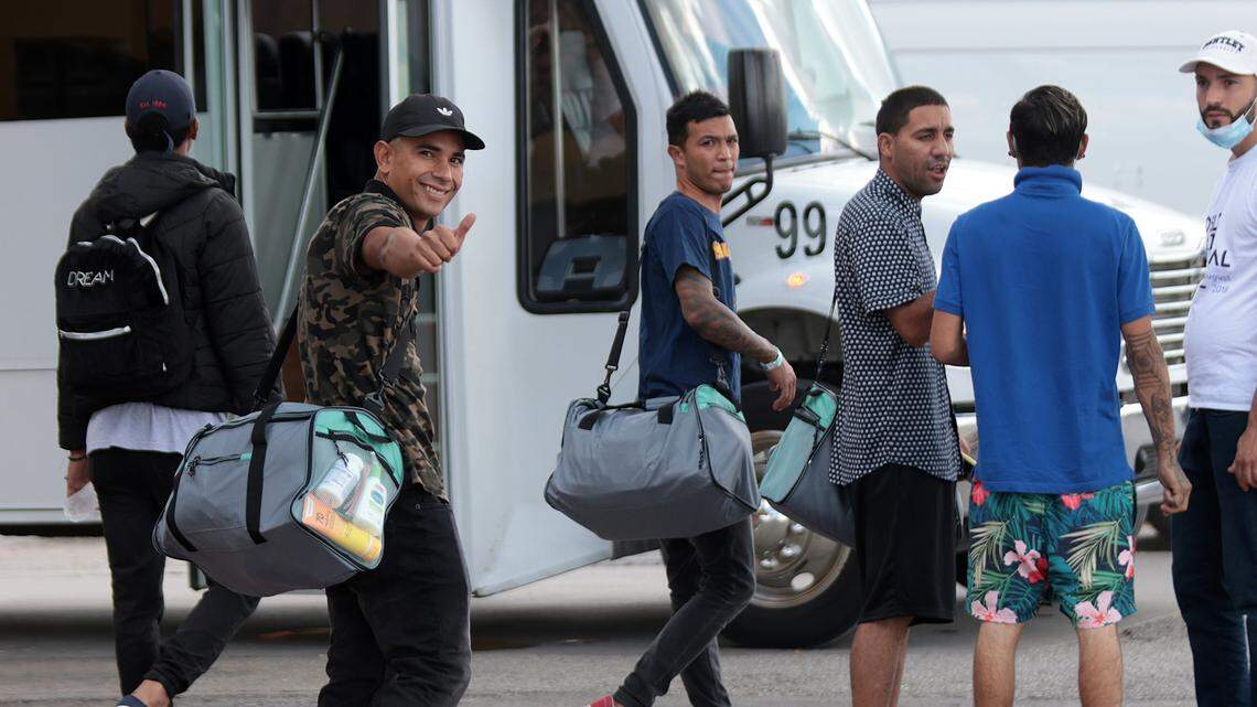 Jesús Guillén, second from left, gives a thumbs up while boarding a bus outside a hotel in San Antonio on Sept. 20, where he stayed waiting for a Vertol-chartered flight that was eventually canceled. His duffel bag was purchased by the company and given to him in preparation for the flight.