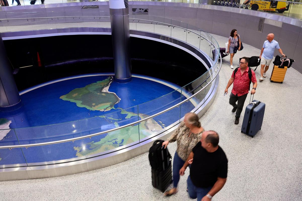 Travelers with their luggage arrive at Miami International Airport in Miami, Florida, on Tuesday, November 12, 2024.