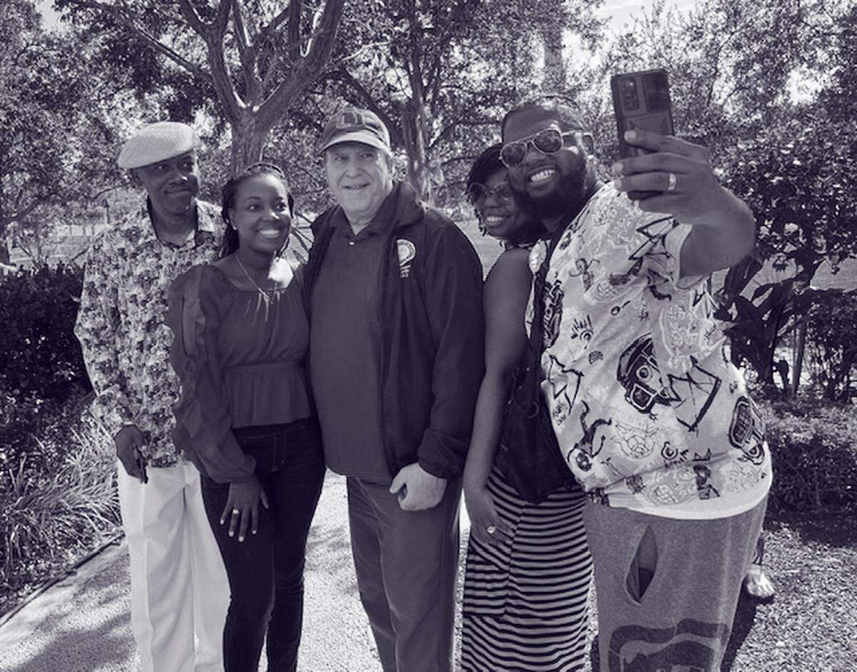 Joe Carollo (al centro) posando para una foto con turistas de Colorado en Ferré Park, en downtown Miami.
