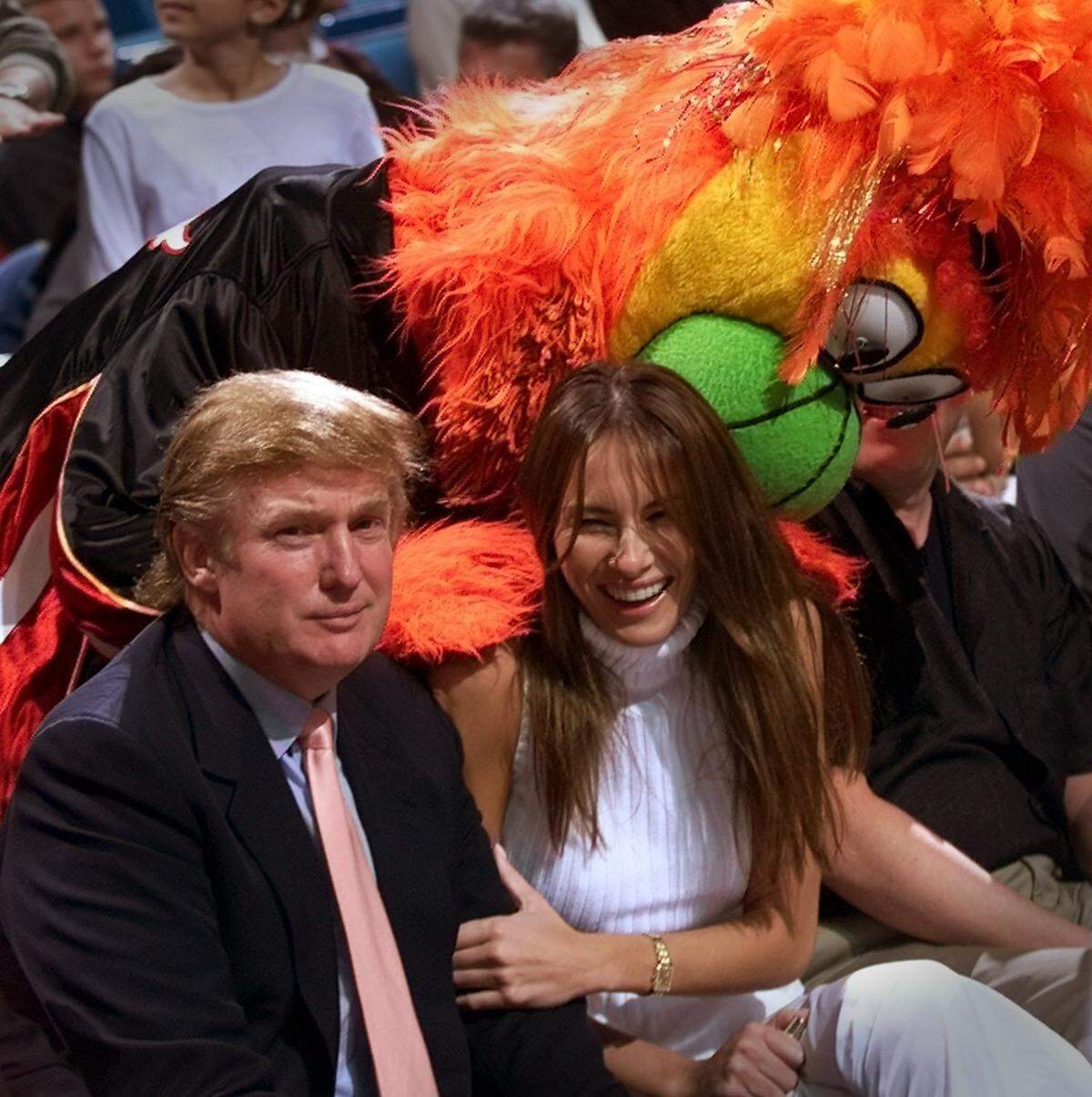 In 1999, Donald Trump and then girlfriend Melania get a kiss from Miami Heat mascot Burnie before a game.