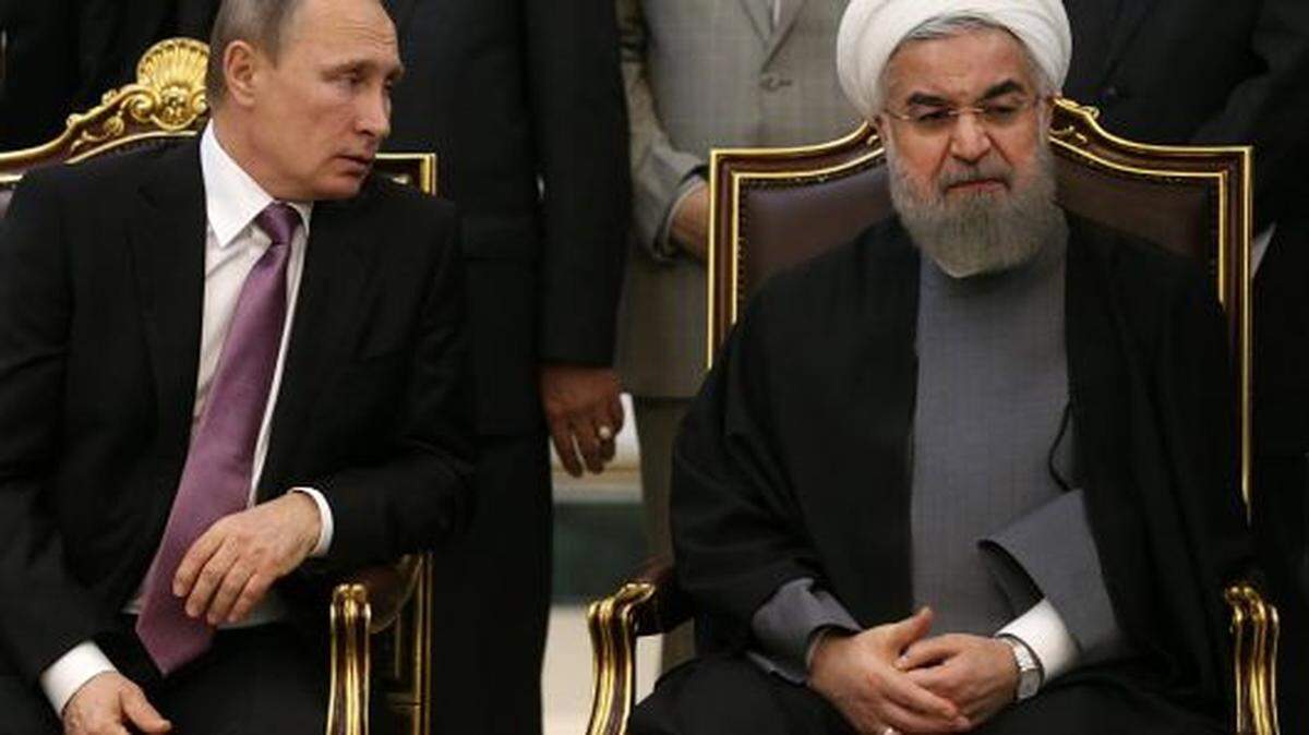 Russian President Vladimir Putin, left, with Iranian President Hassan Rouhani, slammed U.S. sanctions against Iran.