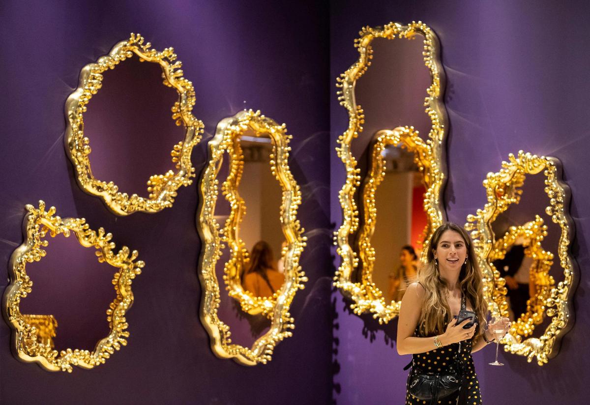 Sofia Poma explores a work by Haas Brothers at the Gallery ALL booth during Design Miami on Tuesday, Nov. 29, 2022, in Miami Beach, Fla.