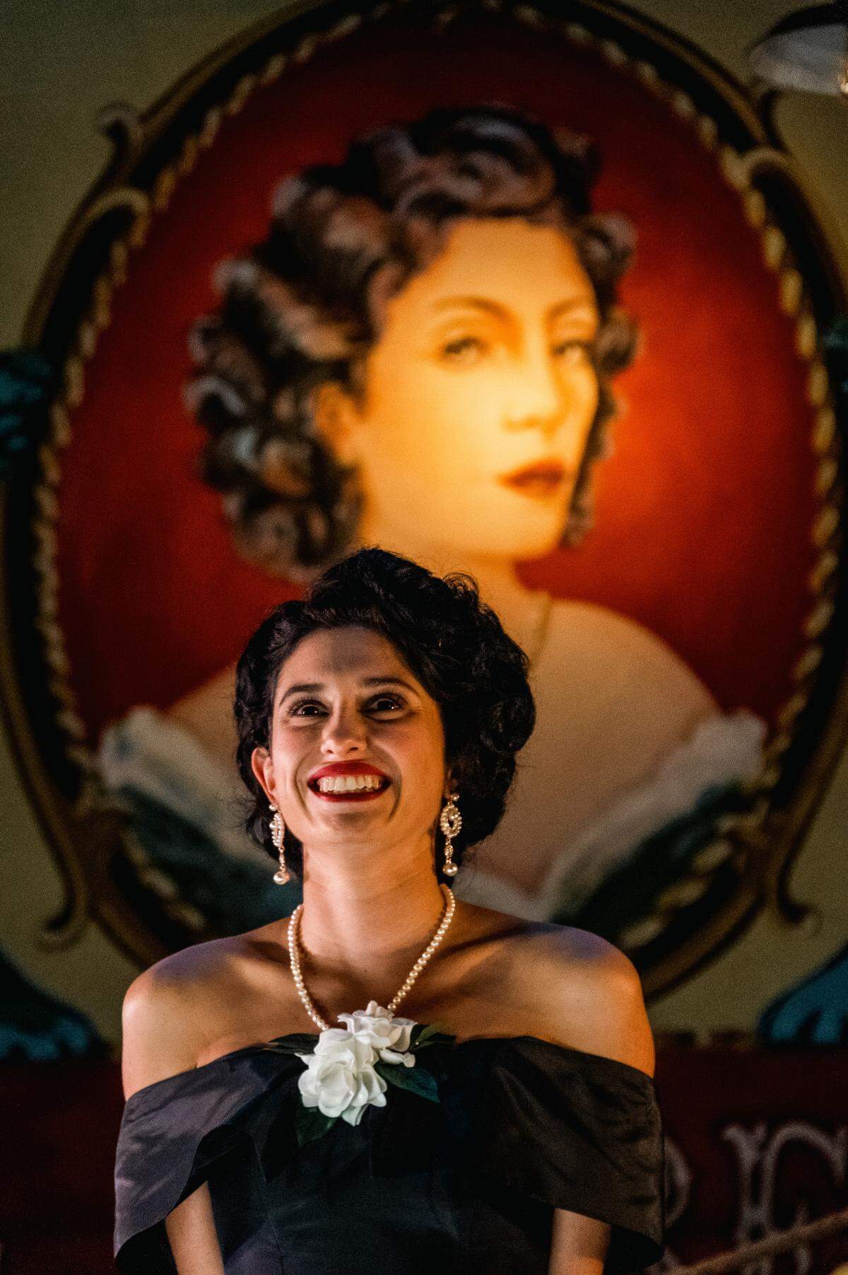 Andrea Ferro’s Marela poses with her cigar-label portrait in Miami New Drama’s 20th anniversary production of “Anna in the Tropics.”