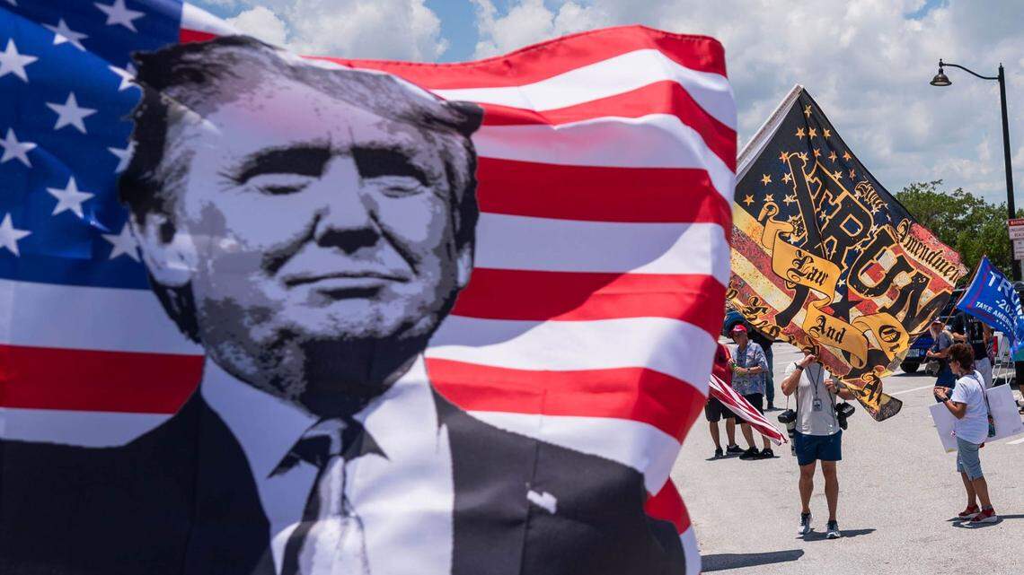 Supporters of former President Donald Trump wave flags at passing traffic during a pro-Trump event on June 11, in West Palm Beach, Florida.