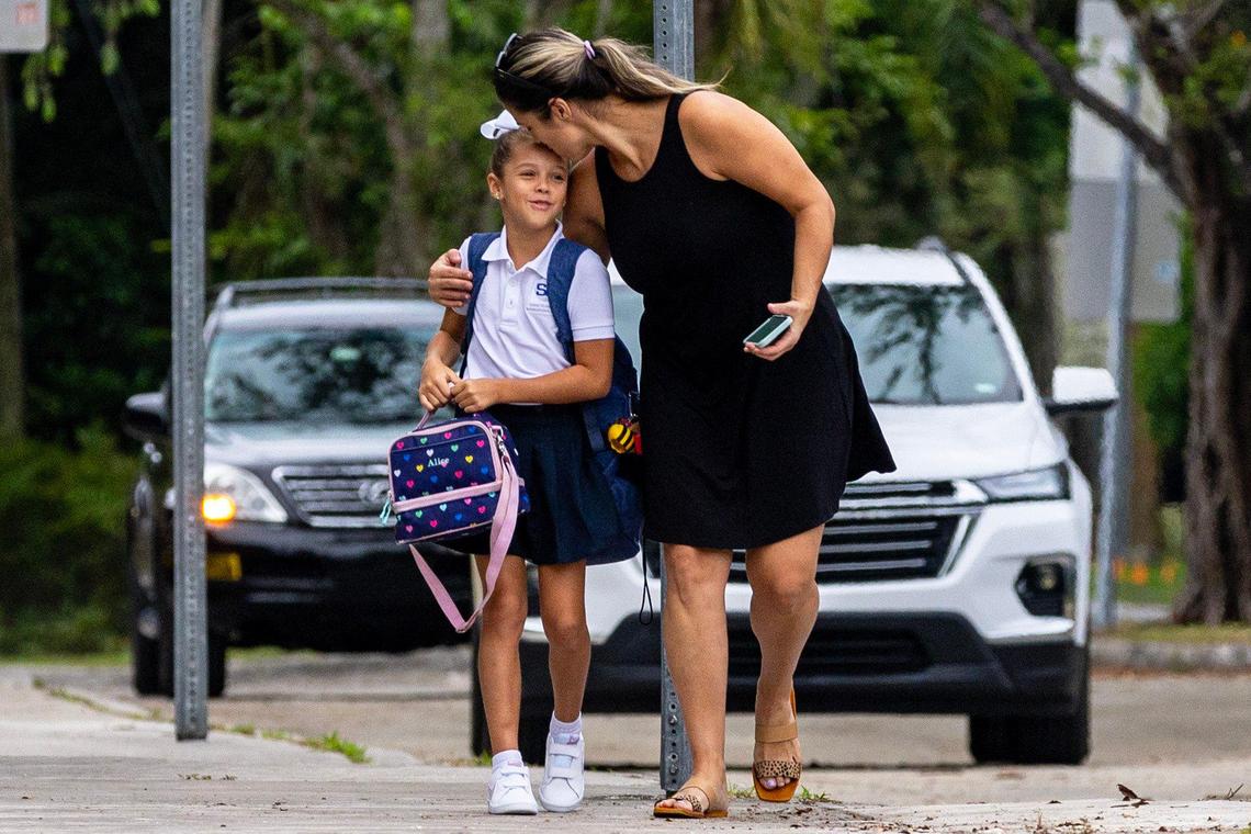 Yodi Martinez hugs and kisses her daughter Alice Fatjo before dropping her off for the first day of school at Sunset Elementary in Miami, Florida, on Thursday, Aug. 17, 2023.