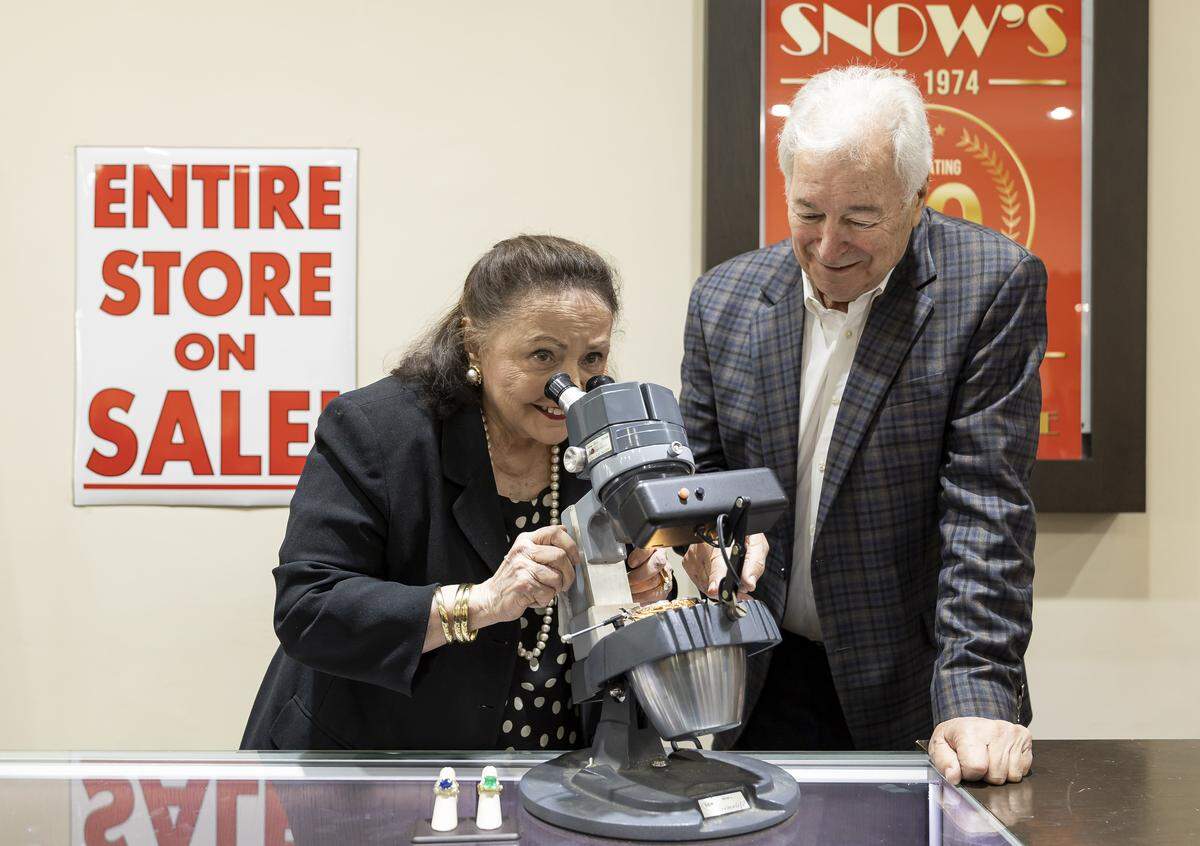Eddie and his wife, Judy Snow, examine a piece using a jeweler's microscope at Snow's Jewelers on Friday, Jan. 9, 2025, in Coral Gables, Fla. The jewelry shop, which has operated for more than 50 years, is closing its Miracle Mile location as owners Eddie and Judy prepare to retire in April.