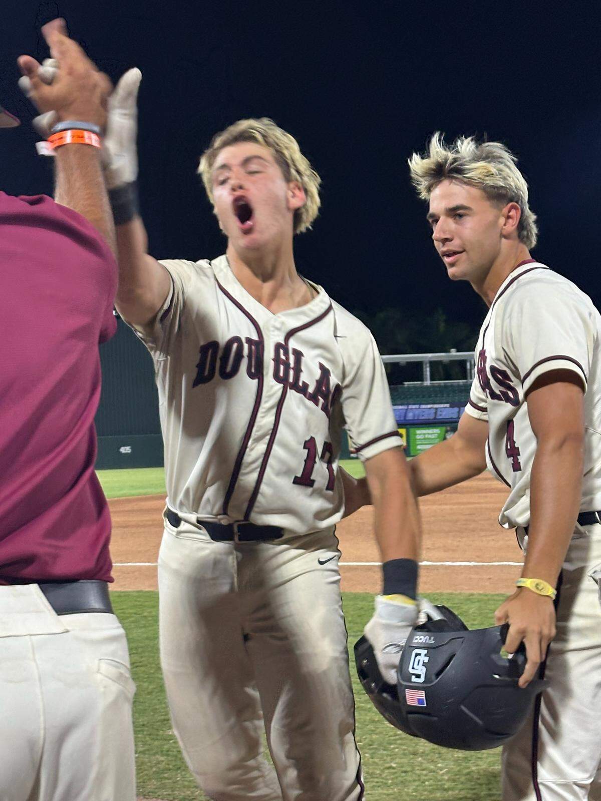 A fired up Douglas catcher Jackson Taylor high-fives a coach after his game-tying hit in Friday’s 9-8 walk-off win over Oviedo Hagerty in a Class 7A state semifinal at Hammond Stadium in Fort Myers, Fla.