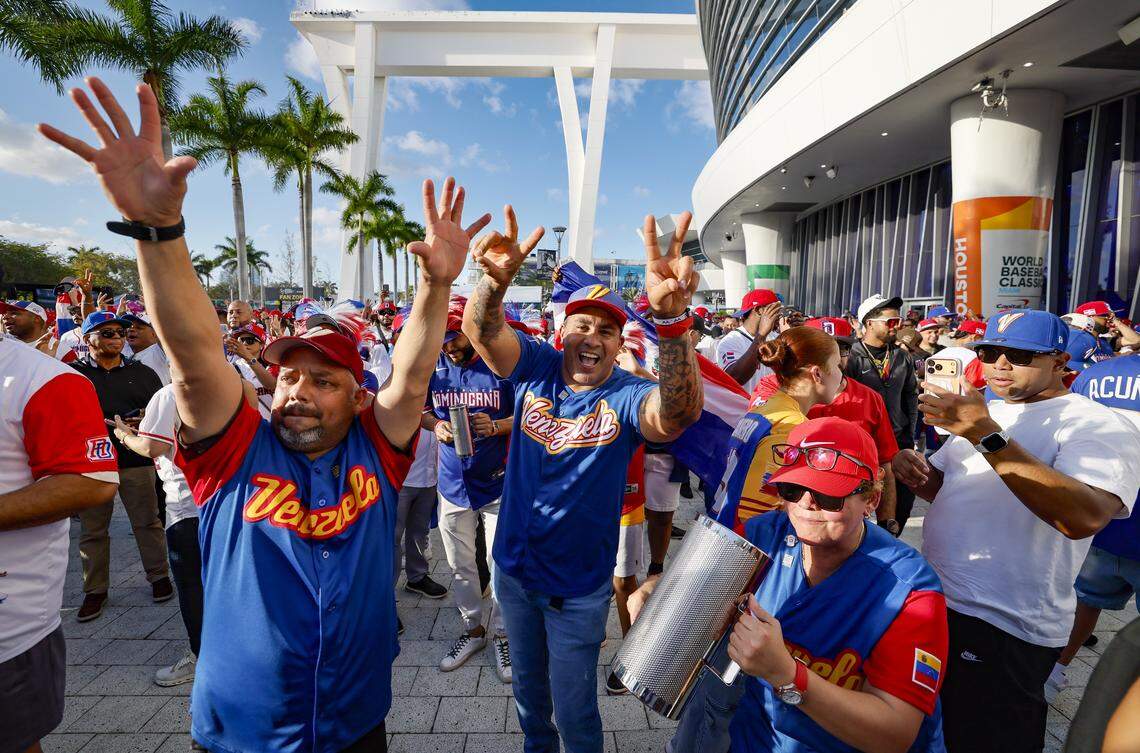 Venezuela fans Darry Liendo, Jose Gabriel and Michele Liendo, left to right. dance to the music beore the start of the World Baseball Classic between Venezuela and Dominican Republic at loanDept park on Wednesday, March 11, 2026.