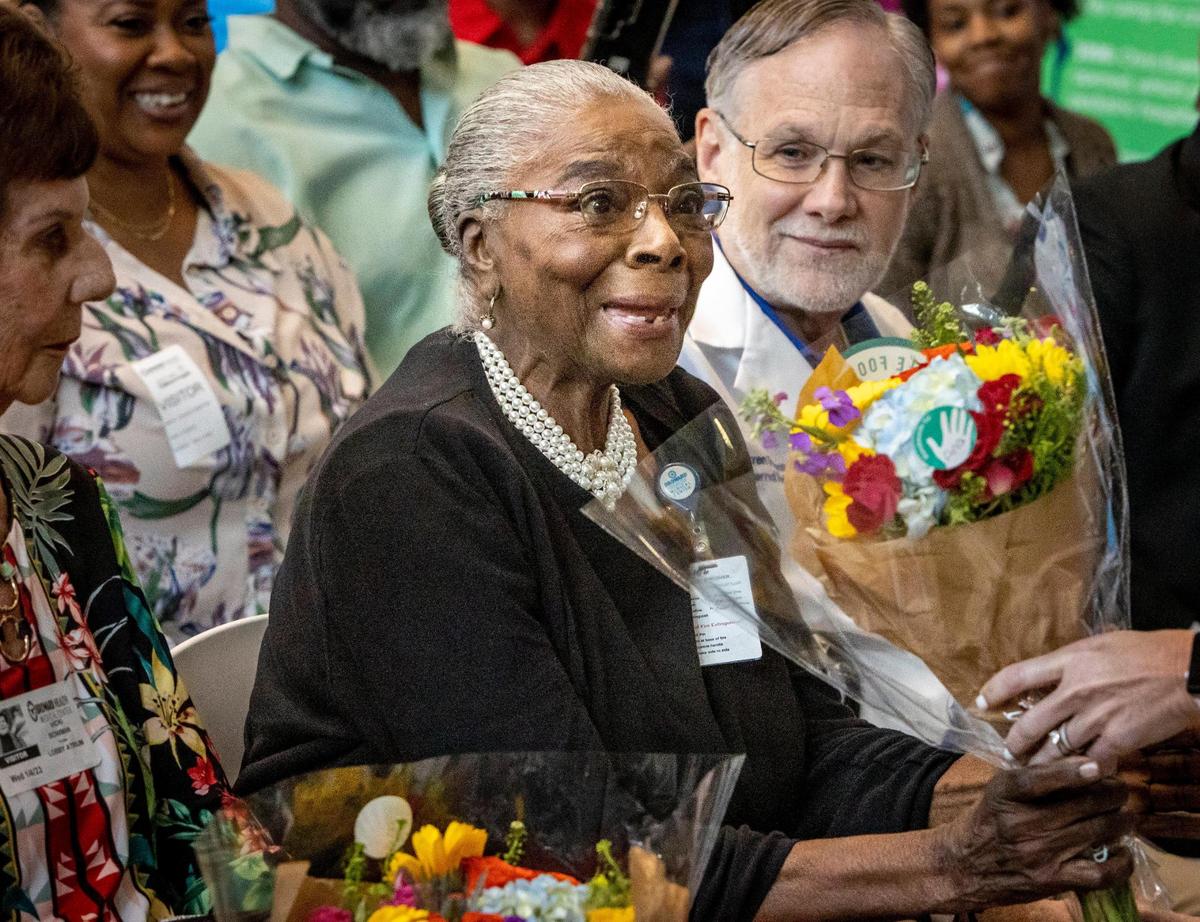 Fort Lauderdale, FL- January 4, 2023 - Thelma Coates, center, an 84-year-old former nursing aid who has worked at the flagship hospital for nearly 60 years reacts as she receives a bouquet of flowers during a ceremony to celebrate Broward Health’s 85th Anniversary held in the main lobby of Broward Health Medical Center,1600 S. Andrews Avenue, Fort Lauderdale