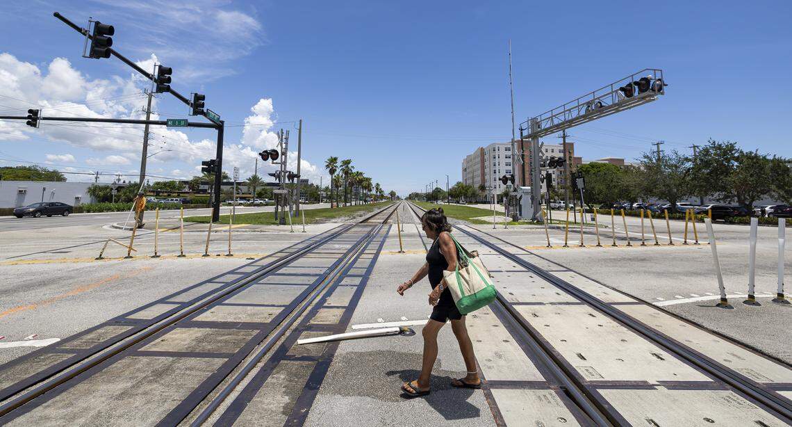 A woman walks over a railroad crossing near North Dixie Highway and Northeast Third Street in Pompano Beach, Florida, where Marie Mevil (not pictured) survived a collision with a Brightline train in November 2021.