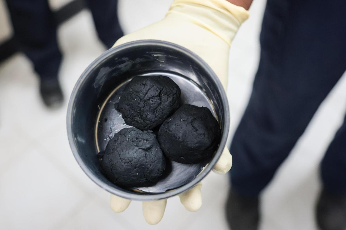 An employee at the Miami-Dade Water and Sewer Department holds a sample of sludge, a solid waste product created by wastewater treatment plants, during a tour of the Central District Wastewater Treatment Plant in Virginia Key, Florida, on Thursday, Jan. 16, 2025.