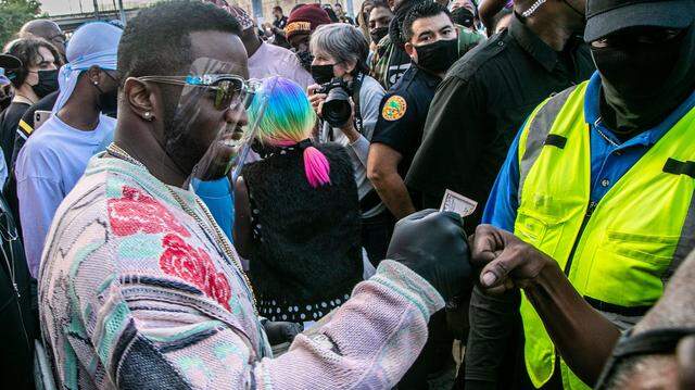 Sean Diddy Combs hands out money and gift cards in December 2020 in Miami as part of his foundation. On Tuesday, Sept. 17, 2024, federal prosecutors in New York unsealed his indictment, which alleges he ran his business as a ‘criminal enterprise’ engaged in sex trafficking, forced labor and bribery, including at his Star Island mansion in Miami Beach.