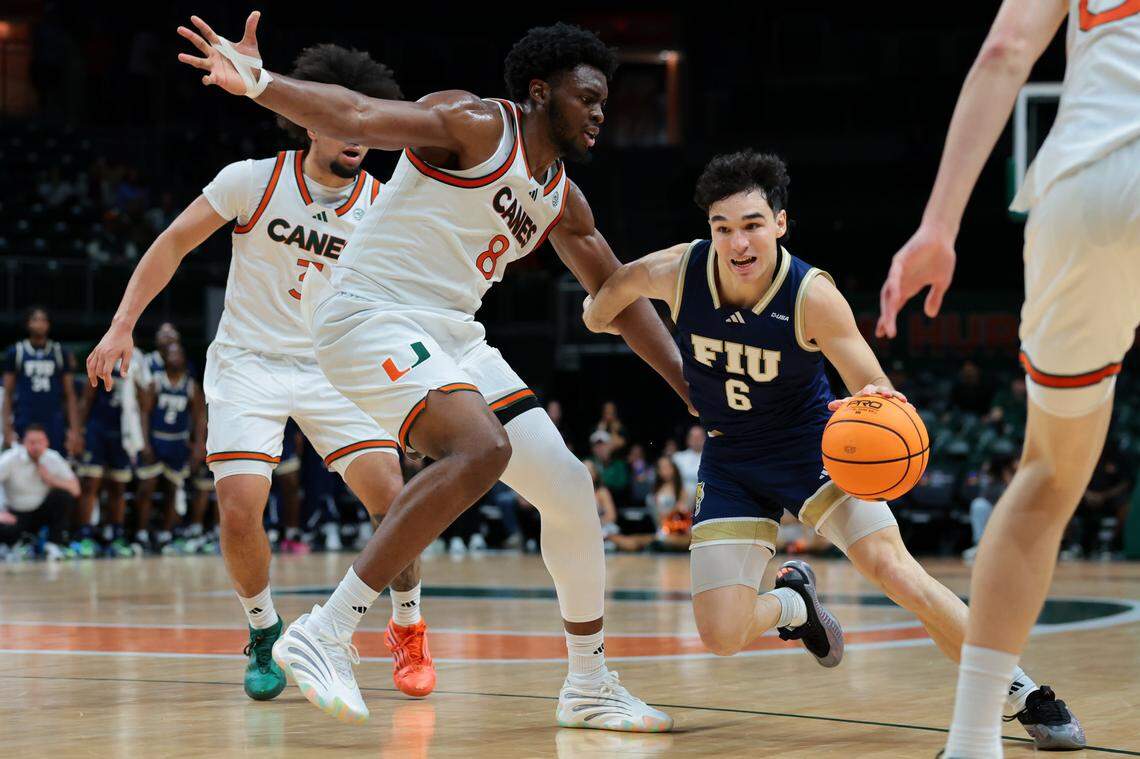 FIU Panthers guard Thiago Sucatzky (6) drives to the basket against Miami Hurricanes center Ernest Udeh Jr. (8) during the first half at Watsco Center on Tuesday, Dec. 16, in Coral Gables, Fla.