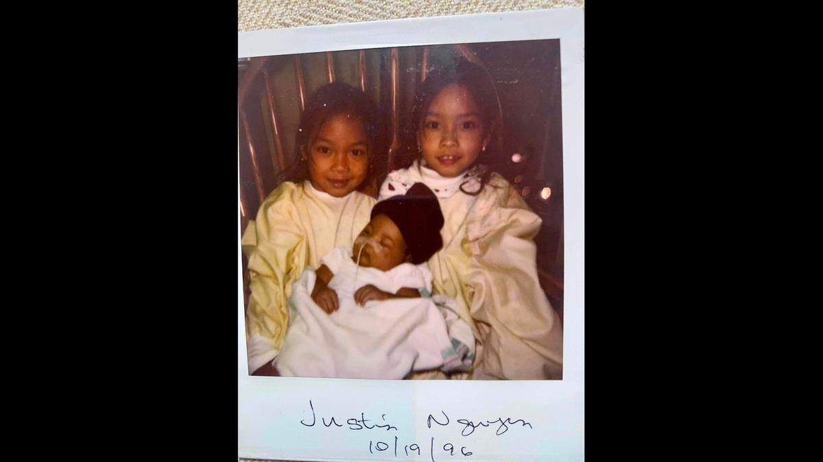 Jennifer, left, and Jessica Pham visit their brother, Justin Nguyen, at the hospital after his birth and emergency surgery. The nurses would take Justin from his incubator and place him in his sisters’ arms. They could hold him only for a short time because of his delicate condition.