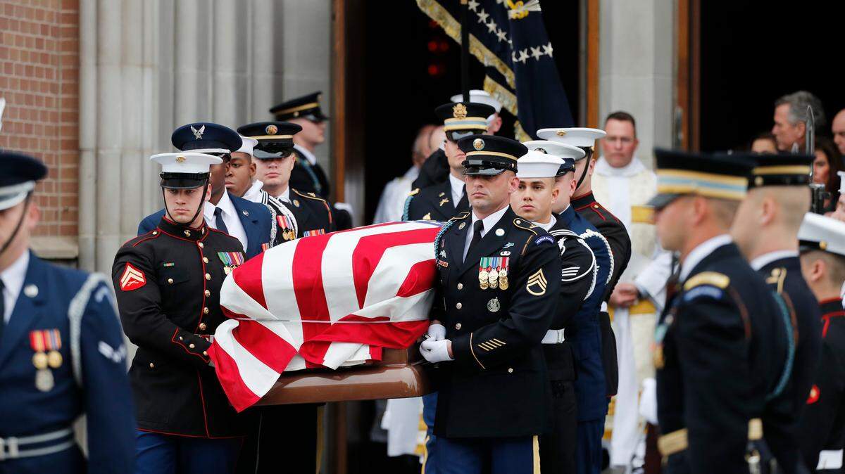 A military honor guard carries the flag-draped casket of former President George H.W. Bush from St. Martin’s Episcopal Church following his funeral service Thursday, Dec. 6, 2018, in Houston.