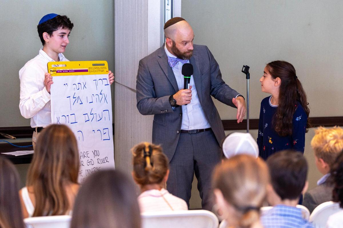Rabbi Jonathan Fisch talks with Reuben Wasserman, left, and Dafna Greenberg, right, during the children’s Rosh Hashana services at Temple Judea in Coral Gables.