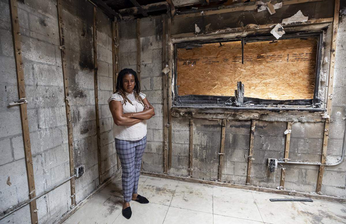 Pauline Dufresne, 39, is photographed in what used to be her bedroom on Wednesday, Nov. 5, 2025, in Miami, Fla. Dufresne, a Haitian TPS holder, lost her home to a fire in July and, without insurance, has been left without power, running water or a place to live. She and her four children are temporarily staying with a nearby neighbor.