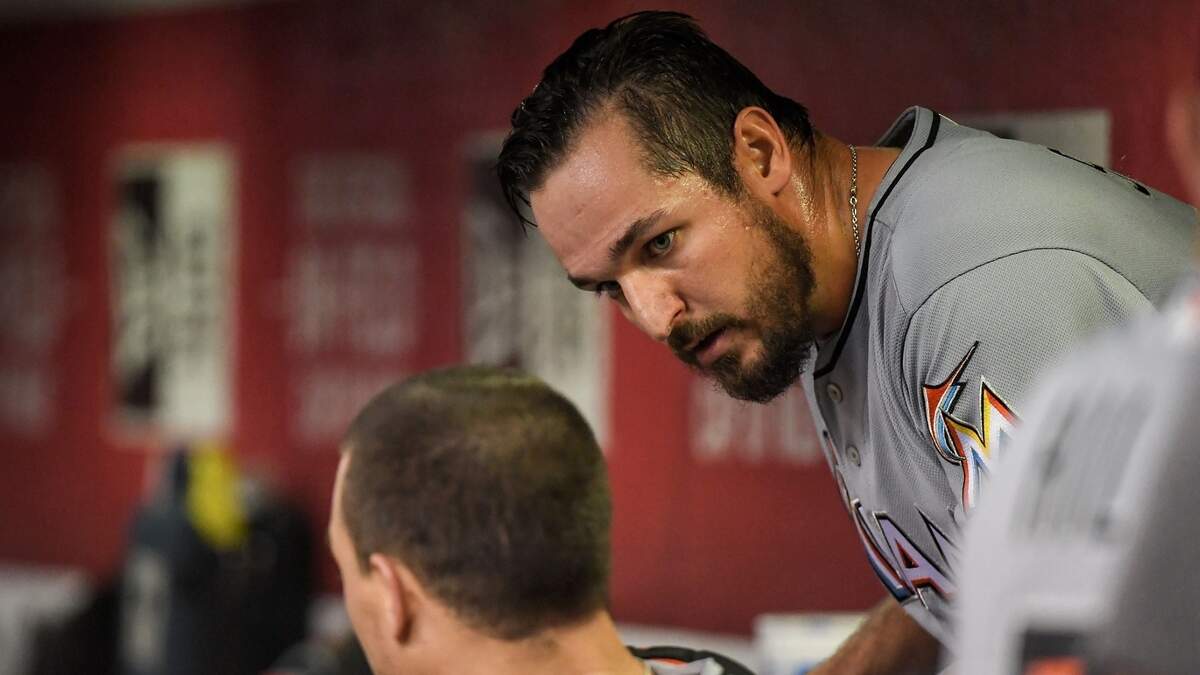 Caleb Smith talks strategy with catcher J.T. Realmuto inside the dugout during the Marlins' loss on Saturday to Arizona.