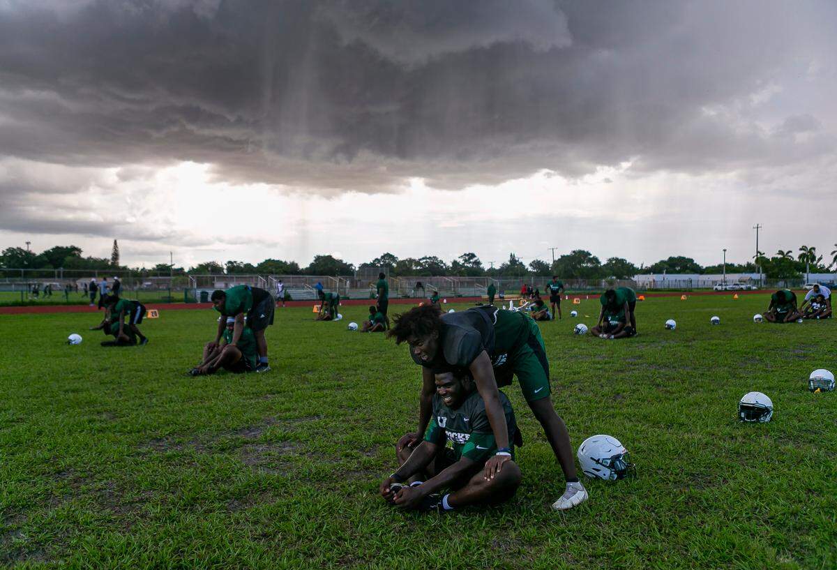 Miami Central football players stretch during a preseason practice at their school’s field in Miami’s West Little River neighborhood on Thursday, August 5, 2021.