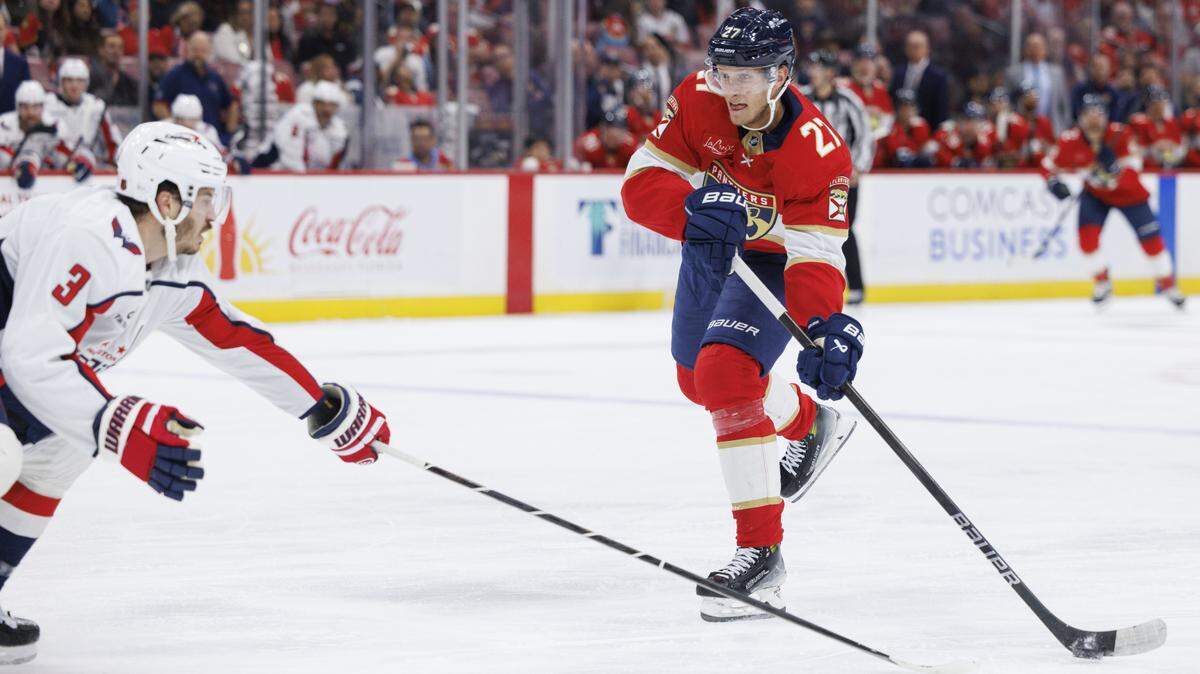 Florida Panthers center Eetu Luostarinen (27) hits the puck around Washington Capitals defenseman Matt Roy (3) during the first period of a game on Thursday, Nov. 13, 2025, at Amerant Bank Arena in Sunrise, Fla.