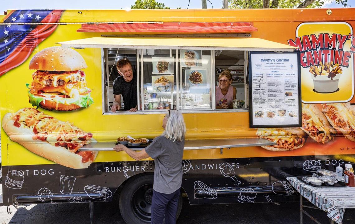 Canadian Danny Haman, 67, serves a customer from Mammy’s Cantine food truck in the Richard’s Motel parking lot in Hollywood, Florida, on Thursday, March 27, 2025.