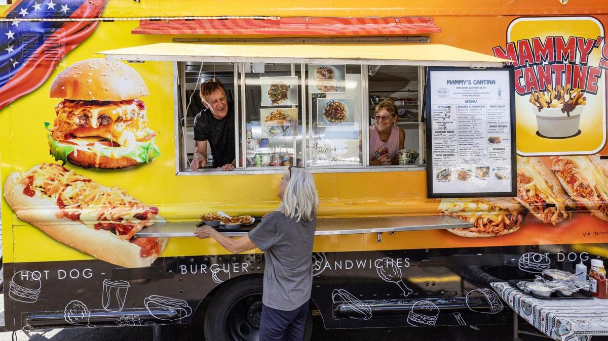 Canadian, Danny Haman, 67, serves a customer from Mammy’s Cantine food truck from a parking lot in Hollywood, Florida, on Thursday, March 27, 2025.