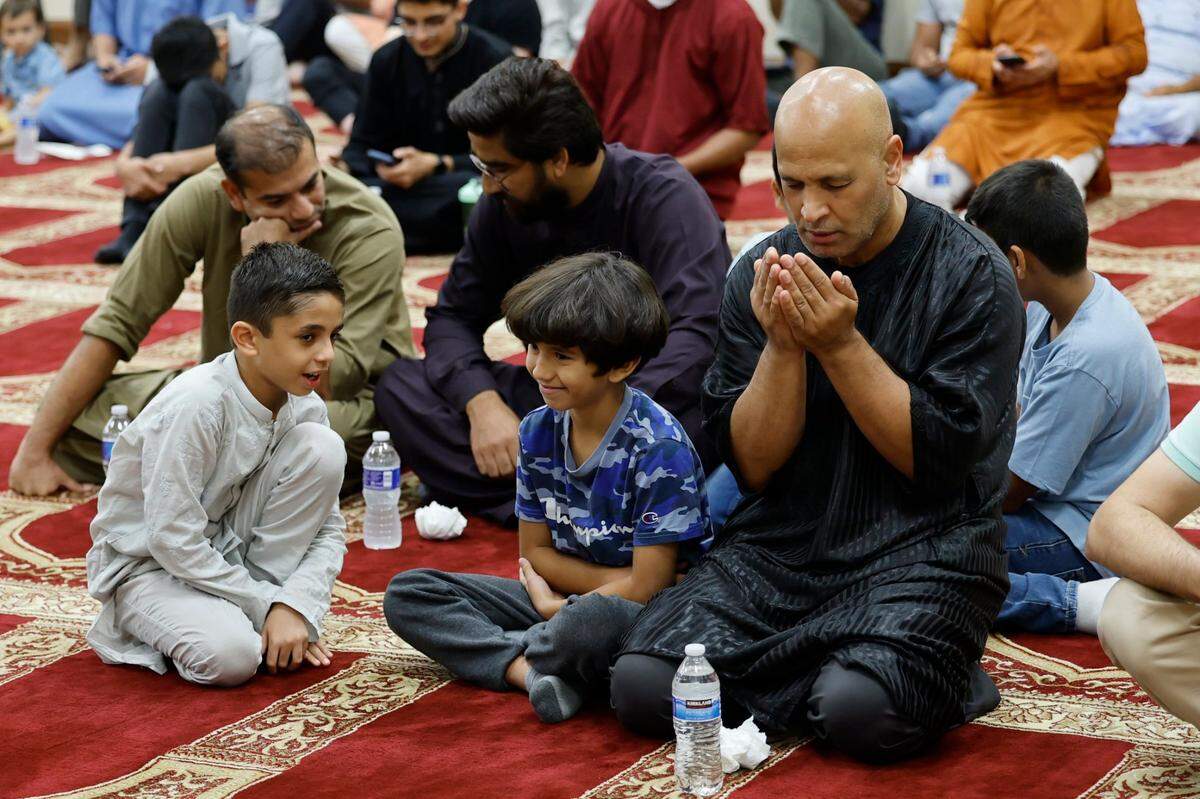 Hass Ouazza celebrates the Day of Arafah with traditional prayer with his son Ramzi Ouazza, 9, and friend Phil Khan, 7, at far left.