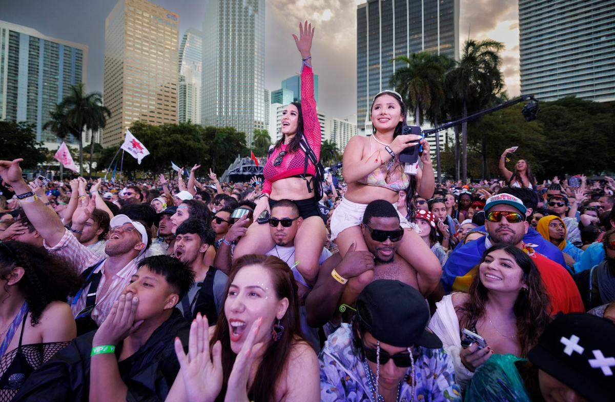 Two girls dance on the shoulders of men while cheering for DJ Steve Aoki during the third day of Ultra Music Festival on Sunday, March 30, 2025, at Bayfront Park in downtown Miami, Fla. 