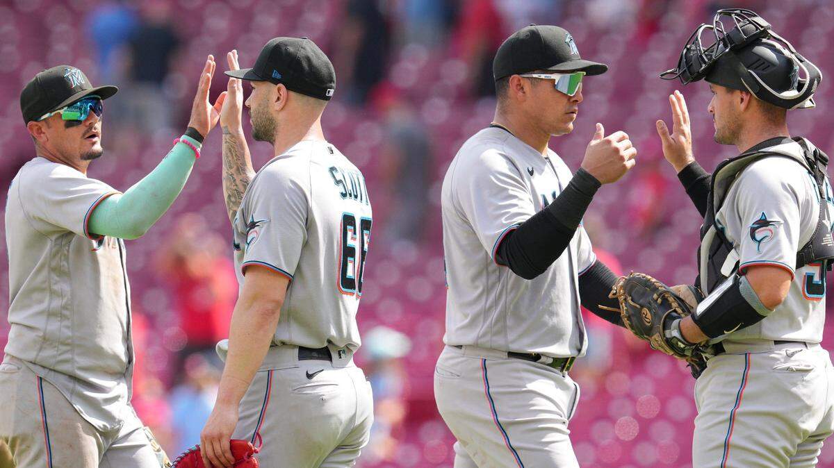 Miami Marlins shortstop Miguel Rojas, left, relief pitcher Tanner Scott (66), right fielder Avisail Garcia, center right, and catcher Nick Fortes celebrate after defeating the Cincinnati Reds in a baseball game Thursday, July 28, 2022, in Cincinnati. (AP Photo/Jeff Dean)