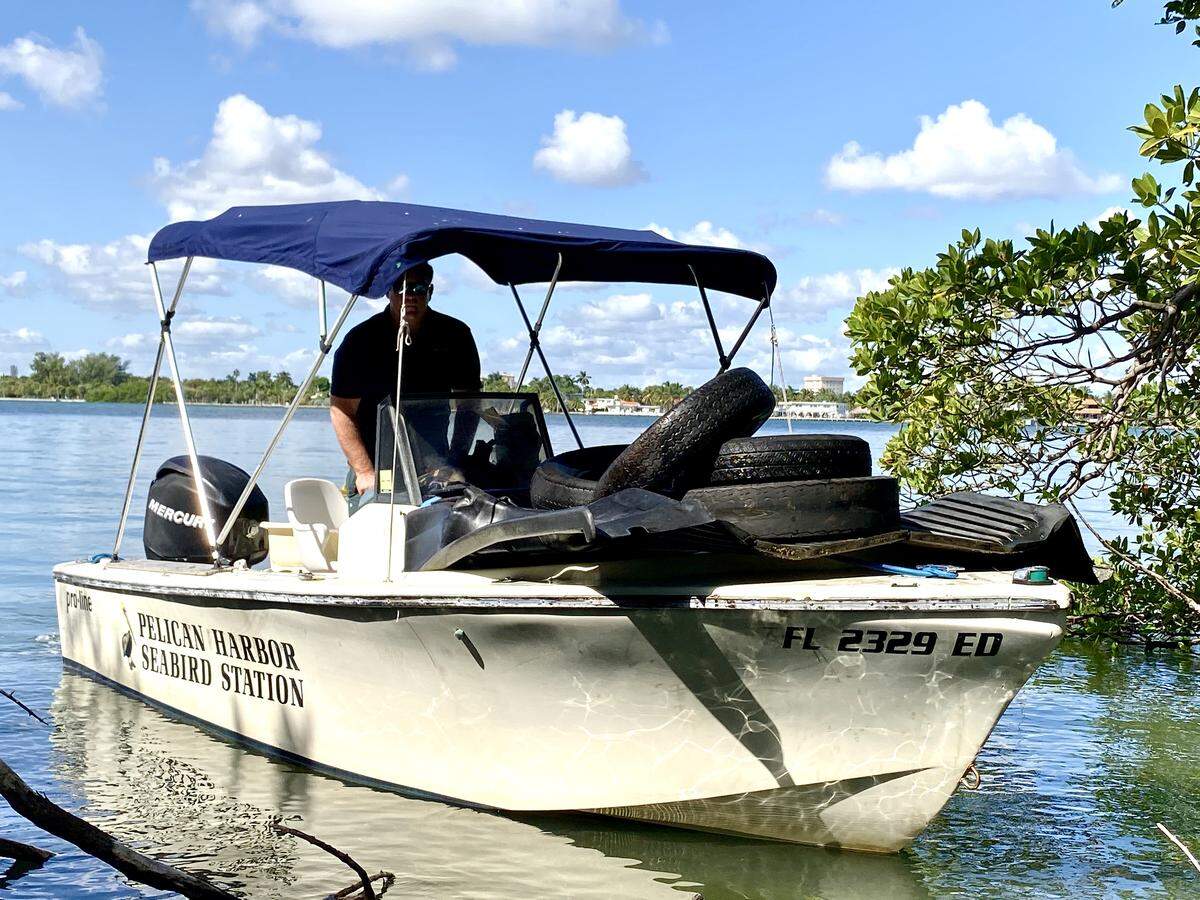 Christopher Boykin with some of the 1.4 tons of trash his crew collected on Bird Key, a private island in Biscayne Bay.