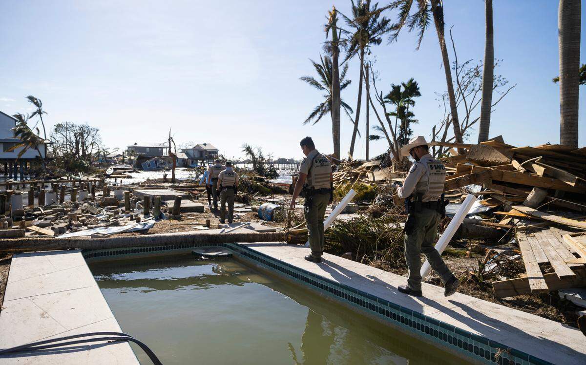 Florida Fish and Wildlife Conservation Commission officials survey damage on Pine Island Road on Thursday, Sept. 29, 2022, in Matlacha, Florida, a day after Hurricane Ian made landfall on the coast of southwest Florida as a Category 4 storm leaving areas with flooded streets, downed trees and scattered debris.