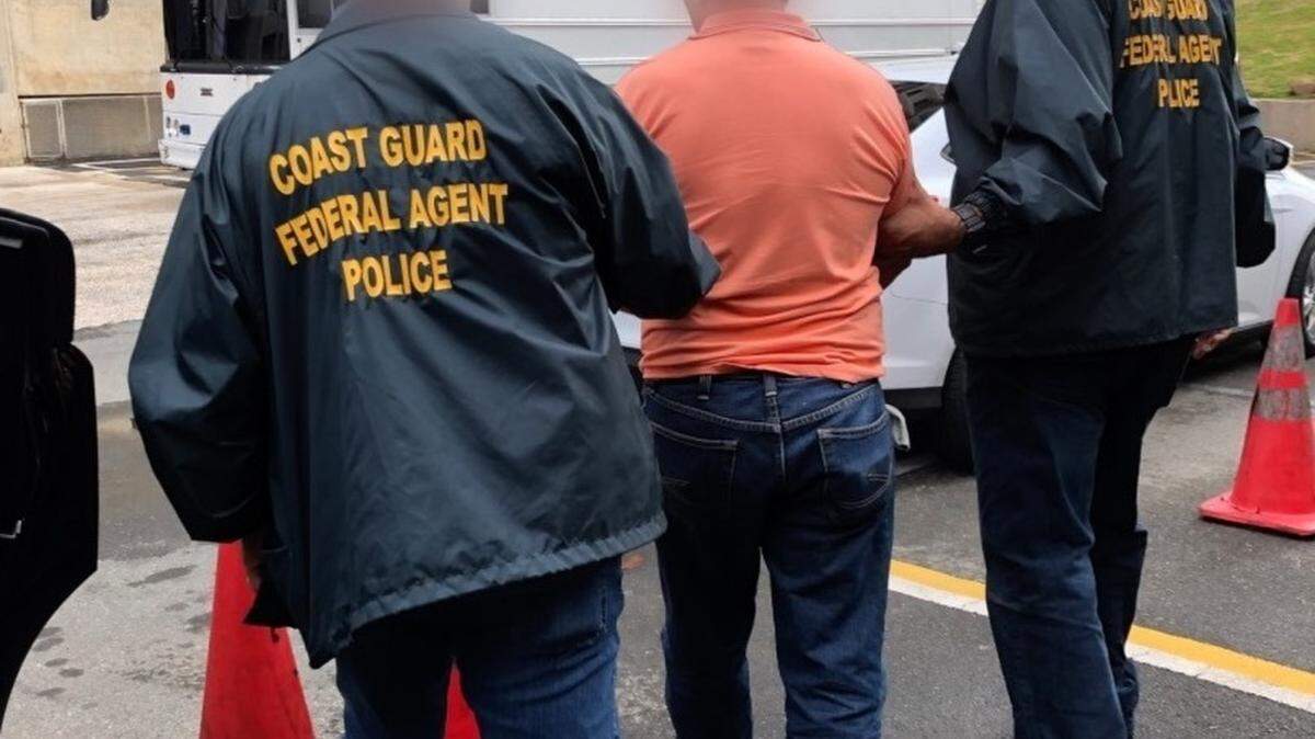 Two Coast Guard Investigative Service agents make an arrest in Puerto Rico, Jan. 17, 2019. The man faces charges of projecting several laser strikes on a Coast Guard Air Station Borinquen MH-65 Dolphin helicopter crew in San Juan, Puerto Rico.