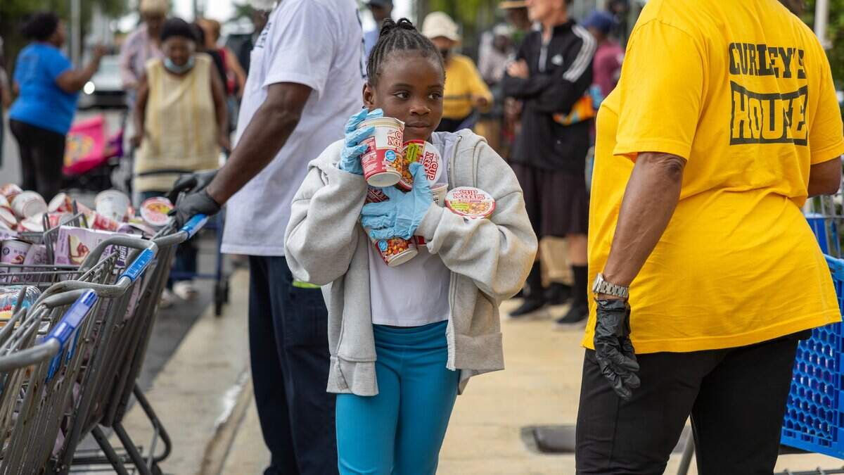 Sarah Philippe, 8, carries food to be distributed at Curley's House Food Bank in Miami on Thursday, June 4, 2026. Sarah volunteered for the first time, alongside her longtime volunteer grandmother and brother.