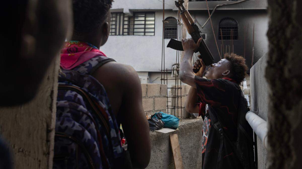 A member of the Viv Ansanm gang coalition fires at a police drone in the Port-au-Prince neighbourhood of Nazon.