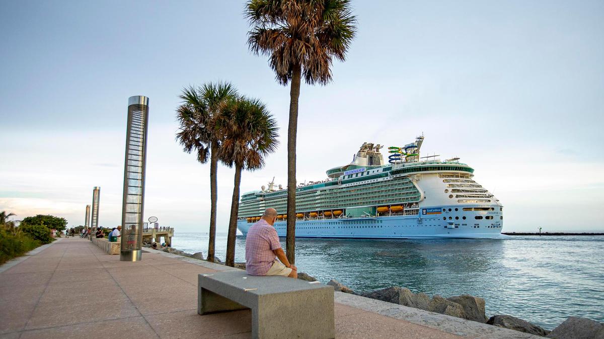 An older man watches as Royal Caribbean International’s Freedom of the Seas cruise ship sets off down Government Cut past South Pointe Park for a simulated voyage leaving from PortMiami in Miami, Florida, on Sunday, June 20, 2021. In accordance with CDC requirements, the purpose of the simulation is to observe the cruise line’s multilayered health and safety measures.
