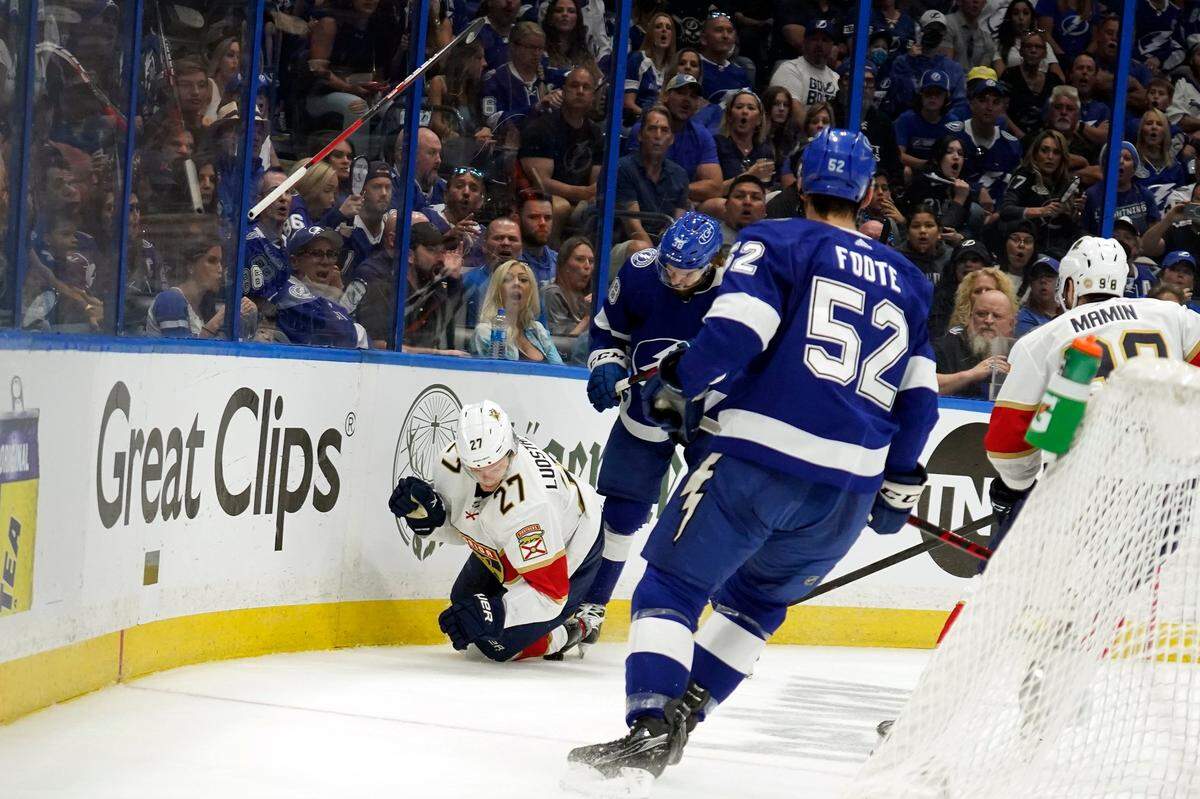 Florida Panthers center Eetu Luostarinen (27) loses his stick after getting cross checked by Tampa Bay Lightning left wing Brandon Hagel (38) during the first period in Game 3 of an NHL hockey second-round playoff series Sunday, May 22, 2022, in Tampa, Fla. (AP Photo/Chris O’Meara)
