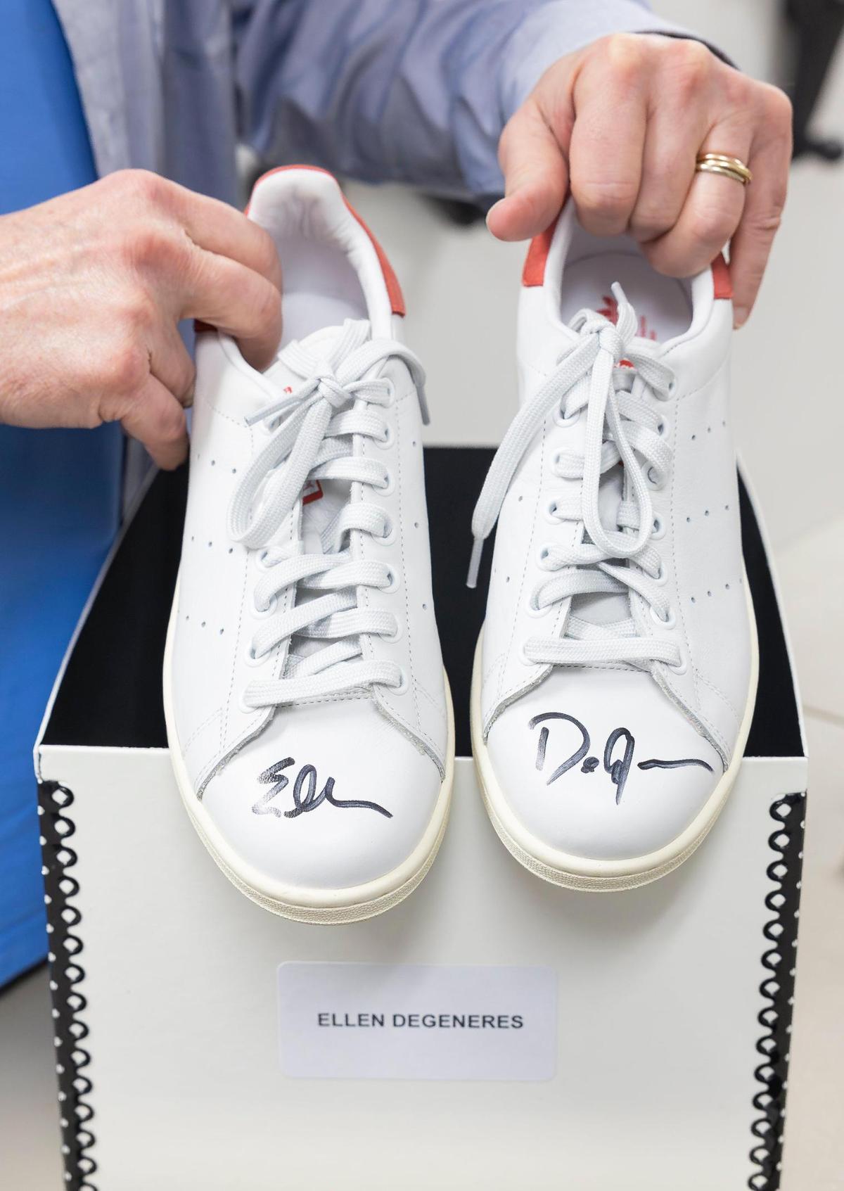 Robert Kesten, the executive director of the Stonewall National Museum, Archives and Library, holding shoes that belonged to comedian Ellen DeGeneres.