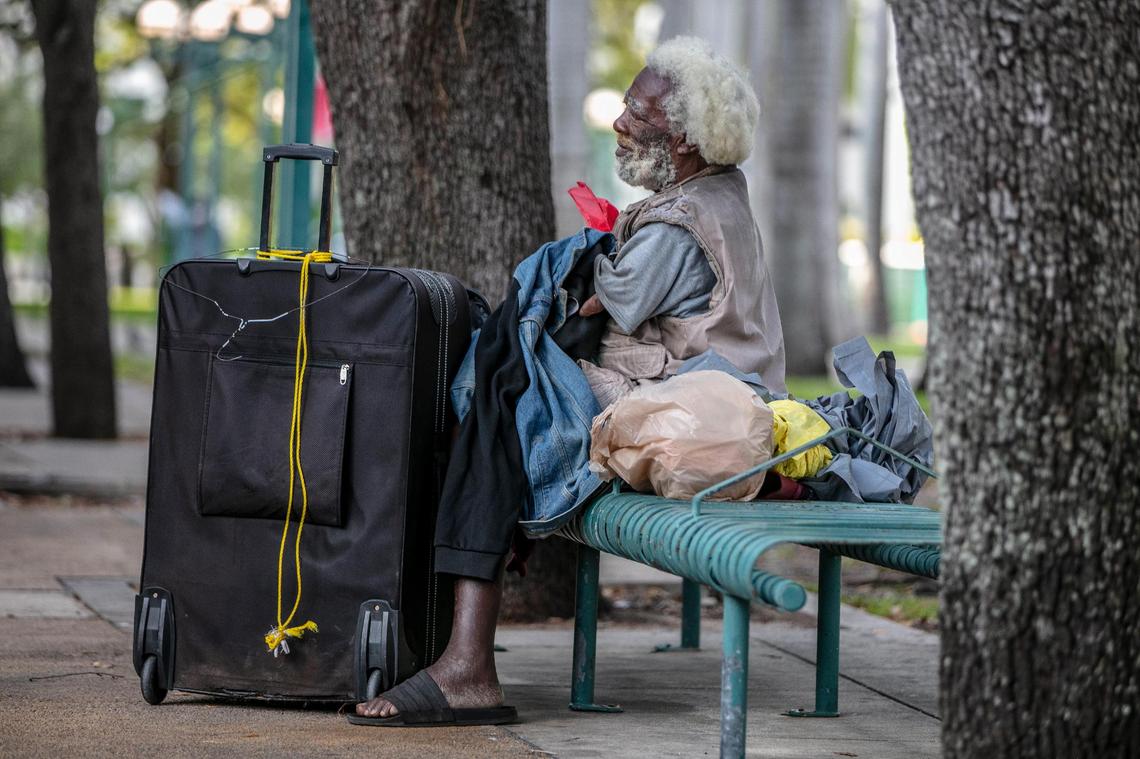 A homeless man sits at a bench behind the Government Center, right across from a mobile vaccination post working to get the COVID-19 vaccine to the homeless population in Miami-Dade County on May 21, 2021.