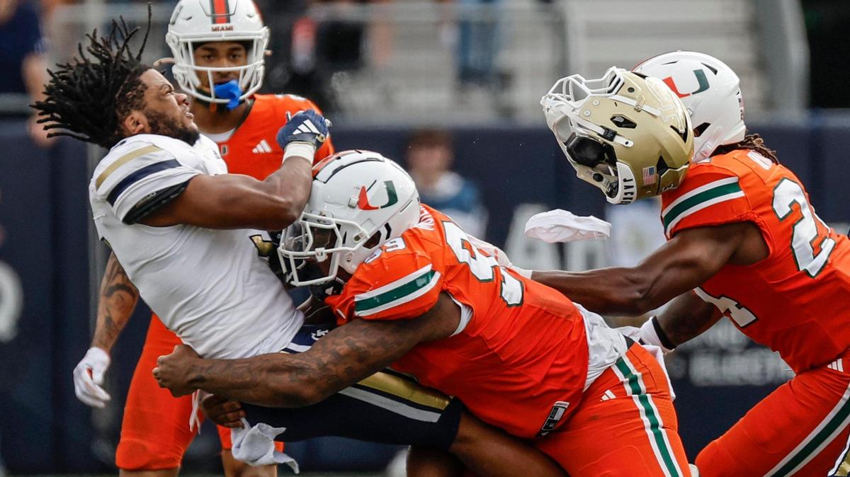 Georgia Tech Yellow Jackets running back Trey Cooley (3) loses his helmet after a hit by Miami Hurricanes defensive lineman Ahmad Moten Sr. (99) in the second half during an NCAA game at Bobby Dodd Stadium at Hyundai Field in Atlanta, Georgia on Saturday, November 9, 2024.