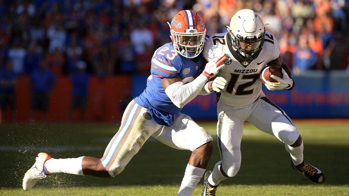Missouri wide receiver Johnathon Johnson (12) is knocked out of bounds by Florida defensive back Chauncey Gardner-Johnson (23) after catching a pass during the first half.