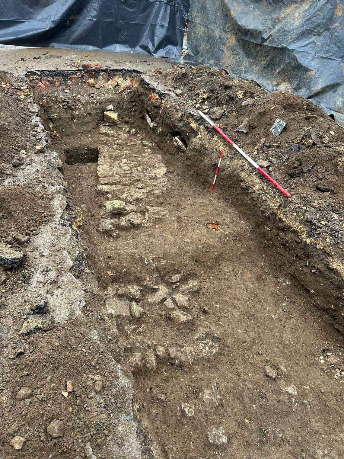 Human burials and a stone wall were found under a parking lot in England dating to the medieval period.